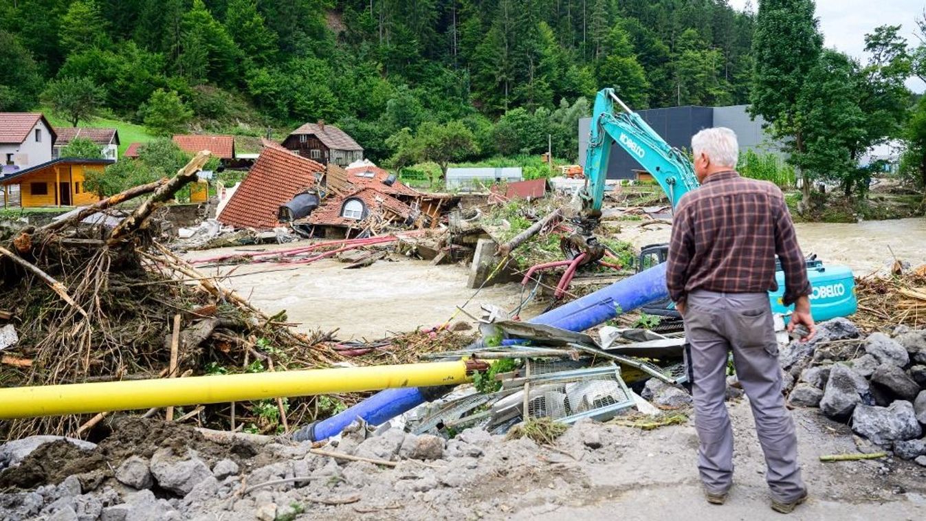 A man looks at a collapsed house on a bank of the Meza river in flood-hit Prevalje, on August 9, 2023. Flash floods and landslides that began on August 3, 2023 had submerged large swathes of central and northern Slovenia, cutting off access to villages and disrupting traffic. (Photo by Jure Makovec / AFP)