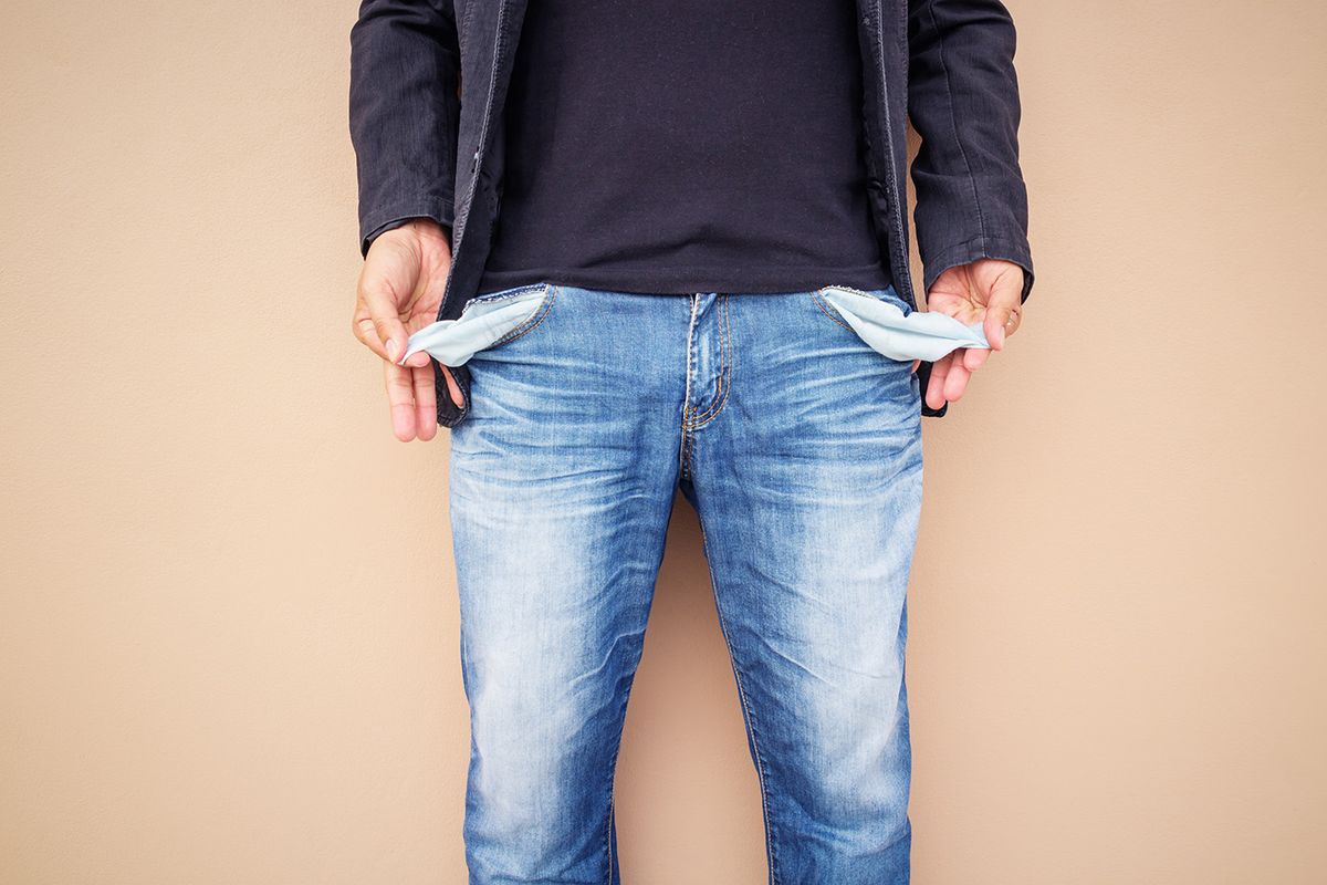 Man,Showing,His,Empty,Pockets,On,Cement,Background.