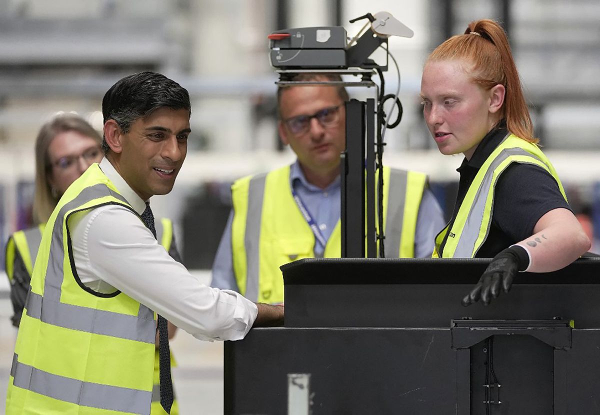 Britain's Prime Minister Rishi Sunak (L) speaks to a worker at a PM Connect event at the IKEA distribution centre in Dartford, Kent, on June 22, 2023. (Photo by Kin Cheung / POOL / AFP)