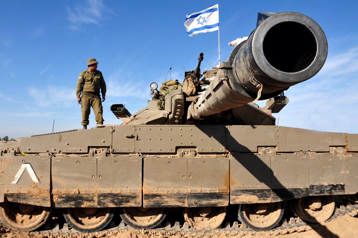 NIR OZ,ISR - JAN 13 2009:Israeli soldier on Merkava Tank Mark IV in Gaza Strip. The tank is Israeli-designed TSAWS system designed to endure the harsh basalt rock conditions of Golan Heights, Israel.