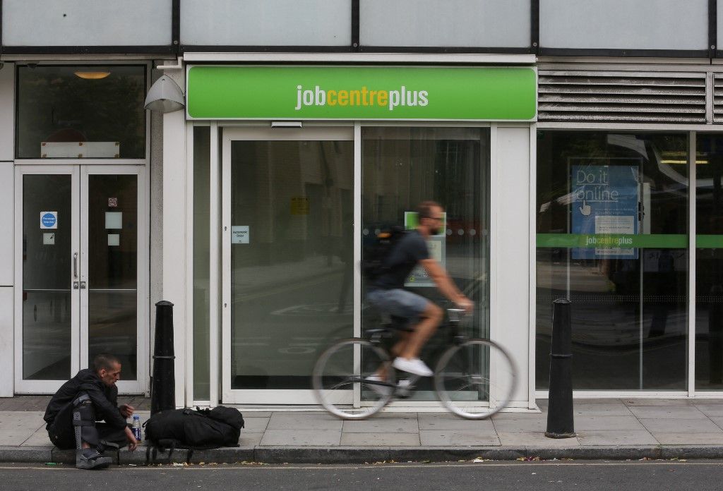 A cyclist passes the entrance to a job centre in east London on July 20, 2016. Britain's unemployment rate dipped to 4.9 percent in the three months to May, the lowest level since 2005, official data showed on Wednesday. (Photo by Daniel LEAL / AFP)
