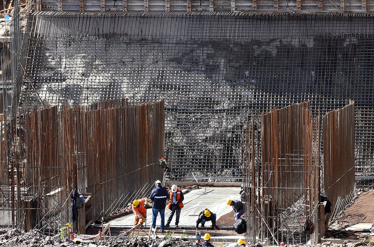 Labourers work at the construction site of the Ańa Cuá project, which is currently 30 percent underway, in the Argentine-Paraguayan bi-national Yacyreta Dam, in Ayolas, Paraguay, on May 30, 2022. (Photo by Norberto DUARTE / AFP)