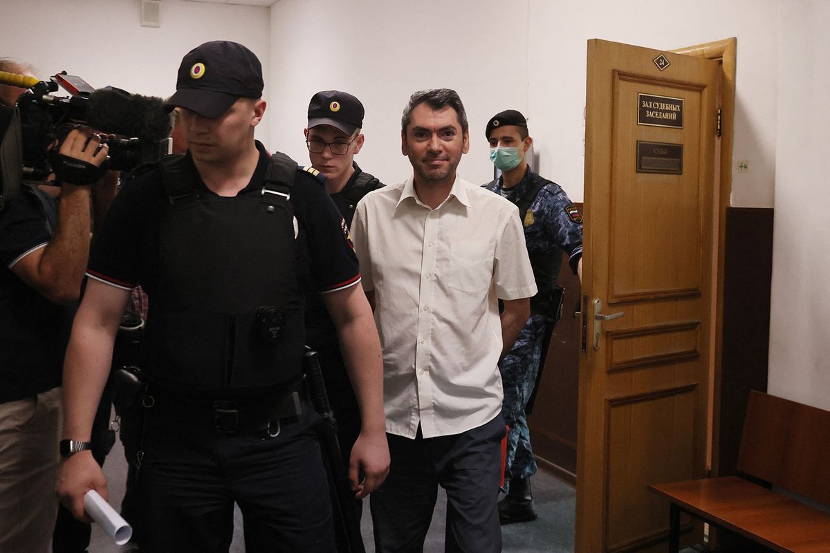 Golos' co-chairman Grigory Melkonyants is escorted outside Basmany Court after his court hearing in Moscow on August 18, 2023. On August 17, 2023, Russian security forces launched mass raids targeting the independent election monitoring group Golos, and its co-chair was taken in for questioning. (Photo by Olesya KURPYAYEVA / AFP)