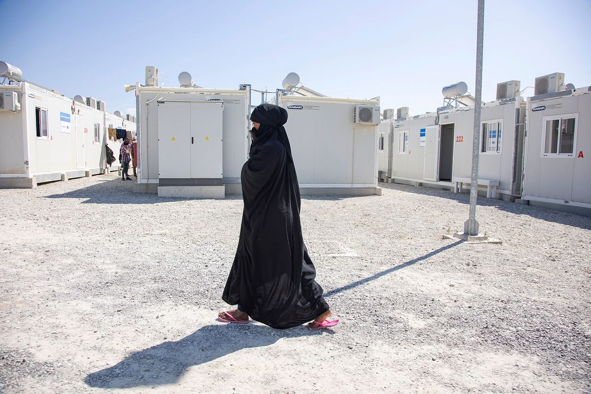 A young woman as seen walking in the camp wearing the traditional muslim abaya. Inside the new Refugee camp in Samos island that has been created in Greece with the support of the EU, as it is the first EU-funded closed controlled facility, the new Samos RIC ( Reception and Identification center) as Europe will spend 276 million euros of EU money for new camps on the islands of Samos, Lesbos, Chios, Kos and Leros . Daily life in the new migrant camp with the prefabricated houses, a closed controlled facility where people can enter only by using their card in addition to their biometrical fingerprint. The new camp can host up to 3500 people split in 8 different main areas according to the group category or ethnicity and there is also a prison like detention facility. On September 21 the authorities moved all the remaining people from the former camp located in Vathi - Samos to the new one without any problems and resistance. Building and additional work is still in process. Police and private security do a screening - security check before entering in the camp. Right now 283 people are located in the new facility that was officially opened a few days ago with European representation. In the camp operate some NGO like euro relief, msf nearby, in addition to IOM and UNHCR. After the relocation asylum seekers complained about the lack of shadow, the quality of food and the distance from the town. The camp has residents from Syria, Iraq, Afghanistan, Somalia and other African countries. The official name is the Closed Controlled Access Center of Samos, run by the Greek government from the Ministry of Migration &amp; Asylum. Zervou, Samos Island, Greece on September 23, 2021 (Photo by Nicolas Economou/NurPhoto) (Photo by Nicolas Economou / NurPhoto / NurPhoto via AFP)