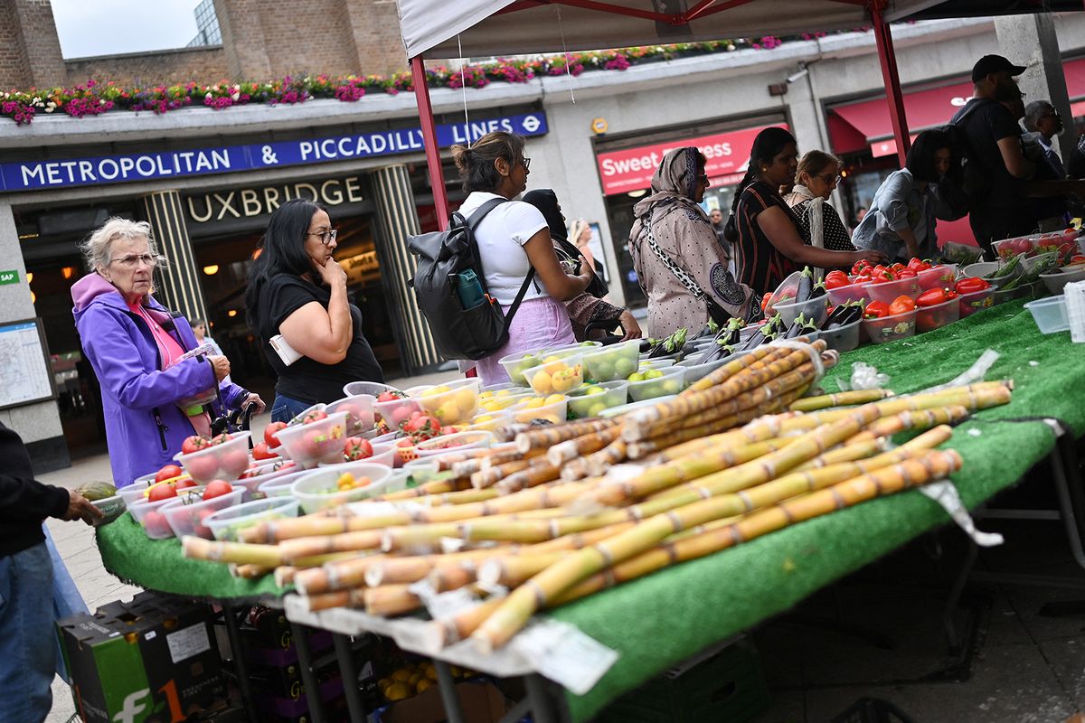 Customers queue outside a fresh fruit and vegetable market stall on the High Street in Uxbridge, west London on July 11, 2023. In the Conservative stronghold of Uxbridge, west London, many voters hope that change is in the air as they prepare to choose former prime minister Boris Johnson's replacement as MP. Johnson quit parliament last month and the opposition Labour Party is favourite to pick up the seat when voters go to the polls on July 20. (Photo by Justin TALLIS / AFP) / TO GO WITH AFP STORY BY Caroline TAIX