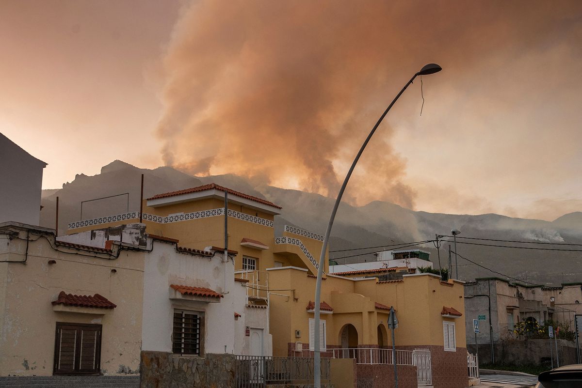 In this picture taken from the village of Arafo on August 16, 2023 smoke columns rise from a wildfire in a forested area of the Guimar valley on the Canary island of Tenerife. Around 250 firefighters battled today a wildfire raging "out of control" on Spain's holiday island of Tenerife that forced the closure of roads and the evacuation of five villages, officials said. The fire, which broke out yesterday night, had so far ravaged about 1,800 hectares (5,500 acres) through a forested area with steep ravines in the northeastern part of the island, part of the Canary Islands archipelago off northwestern Africa. (Photo by DESIREE MARTIN / AFP)