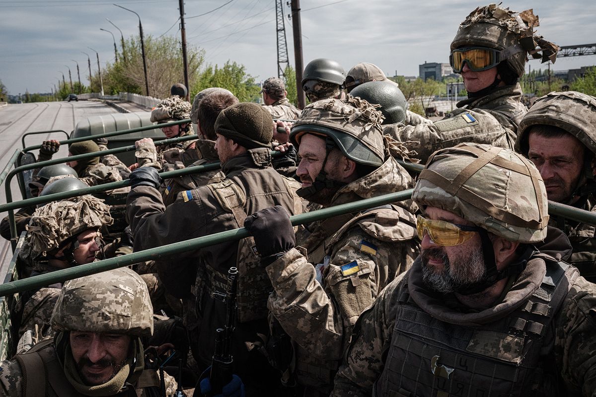 Ukrainian soliders ride in the back of a truck to a resting place after fighting on the front line for two months near Kramatorsk, eastern Ukraine on April 30, 2022. Russia invaded Ukraine on February 24, 2022. (Photo by Yasuyoshi CHIBA / AFP)