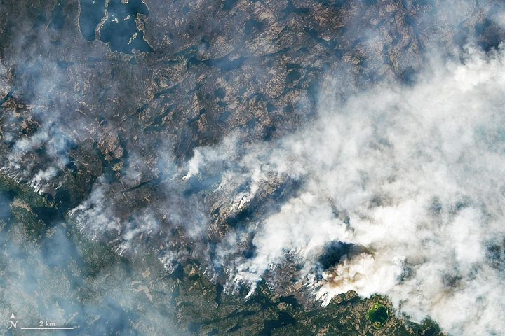 Canada Wildfires 2023: Yellowknife
Aug 16, 2023 - Canada - The Operational Land Imager (OLI) on Landsat 8 captured an image (top of the page) showing several fires burning near Yellowknife at about 18:50 Universal Time (12:50 p.m. local time) on August 16, 2023. The second image (below) is a more detailed view of a fire burning to the northeast. At the time, active fire fronts appeared to be within 20 kilometers (12 miles) of the city. Recently burned areas appear gray, and unburned forests are green. When the image was acquired, smoke streamed to the northeast. Fires Close In On Canadian Town Of Yellowknife