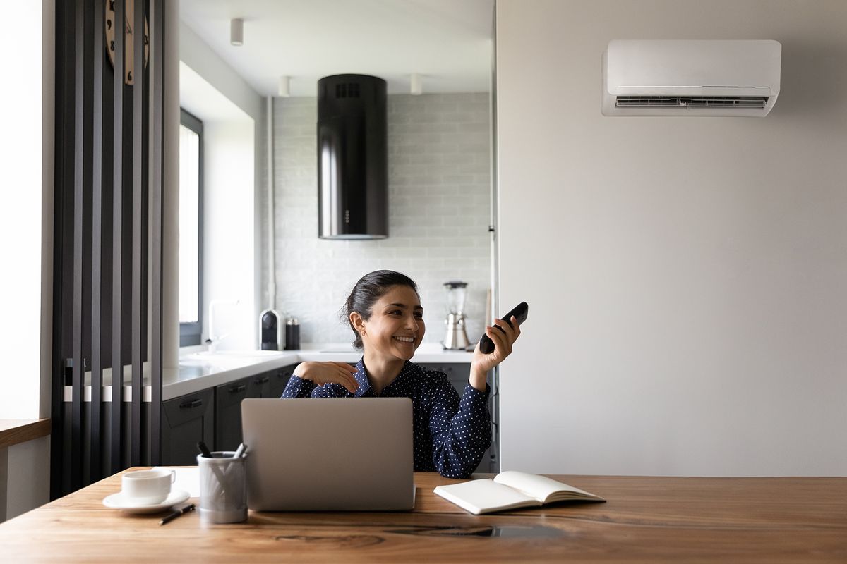Happy,Female,Indian,Student,Or,Employee,Working,From,Home,At
Happy female Indian student or employee working from home at workplace with laptop, using remote control for regulating air conditioner, cooling hot air, relaxing under cold breeze. Comfort concept