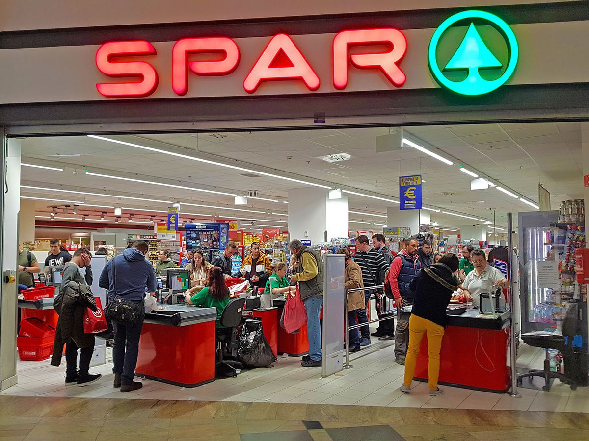 Budapest,,Hungary,-,March,29th,2018:,The,Facade,Of,A
BUDAPEST, HUNGARY - MARCH 29TH 2018: The facade of a very large Spar shop with many customers paying for their groceries at the multiple registers. The name and logo are lit up. Illustrative editorial