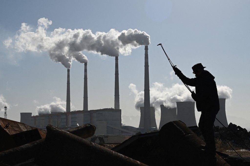 A worker uses a torch to cut steel pipes near the coal-powered Datang International Zhangjiakou Power Station at Zhangjiakou, one of the host cities for the 2022 Winter Olympics, in China's northern Hebei province on November 12, 2021. (Photo by GREG BAKER / AFP)