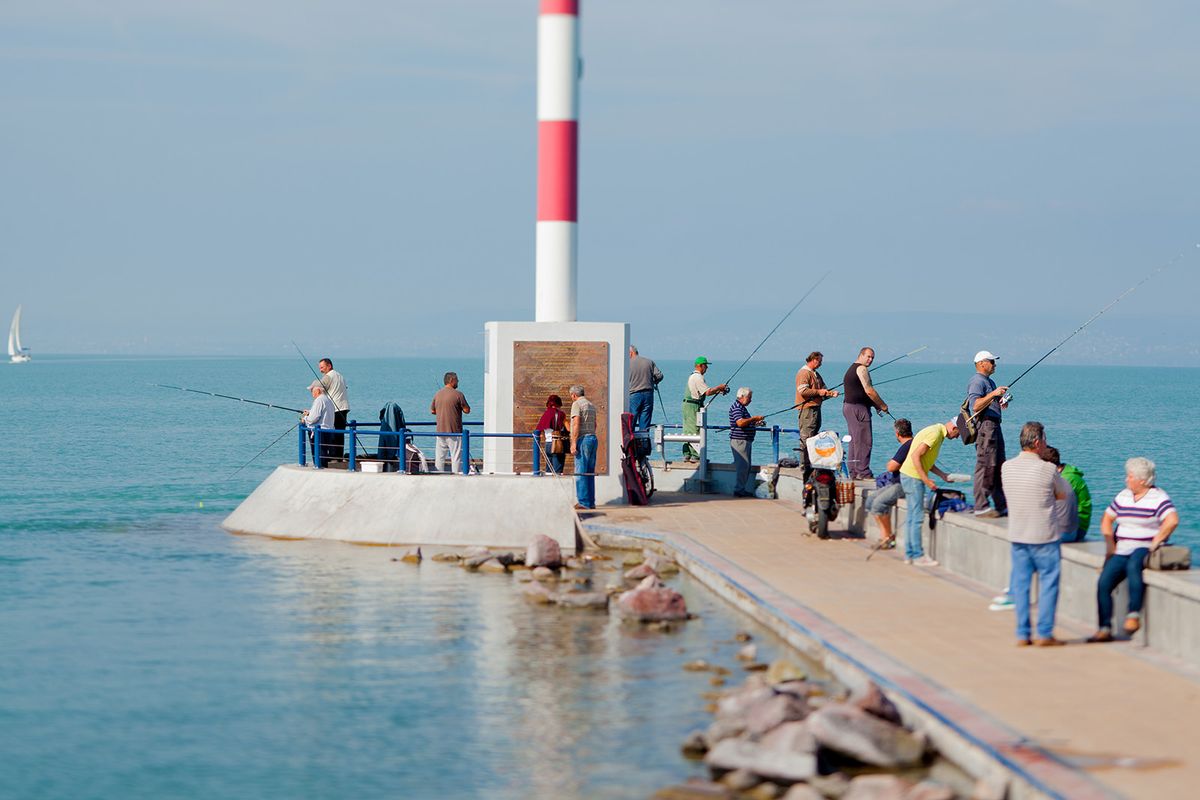 Siofok, Hungary - September 2014. Many man fishing on a pier in Siofok, a city on the Lake Balaton.