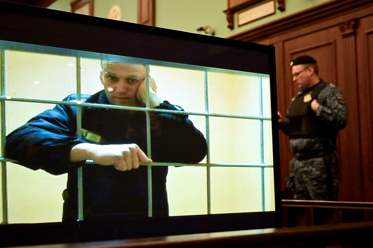 (FILES) Opposition leader Alexei Navalny appears on a screen set up at a courtroom of the Moscow City Court via a video link from his prison colony during a hearing of an appeal against his nine-year prison sentence he was handed in March after being found guilty of embezzlement and contempt of court, in Moscow on May 24, 2022. Russian opposition leader Alexei Navalny faces trial again on August 4, 2023 to hear whether he has been found guilty of "creating an extremist community", a charge that could see him spend 20 more years behind bars. He was already serving a nine year sentence in a maximum security prison for "embezzlement", a charge that his supporters say was trumped up in retaliation for challenging President Vladimir Putin and Russia's political establishment. In a statement to his followers on August 3, 2023, Navalny said that he expected the court to hand him a lengthy, "Stalinist" prison sentence of about 18 years, and called on his supporters to resist Putin's rule. (Photo by Alexander NEMENOV / AFP)