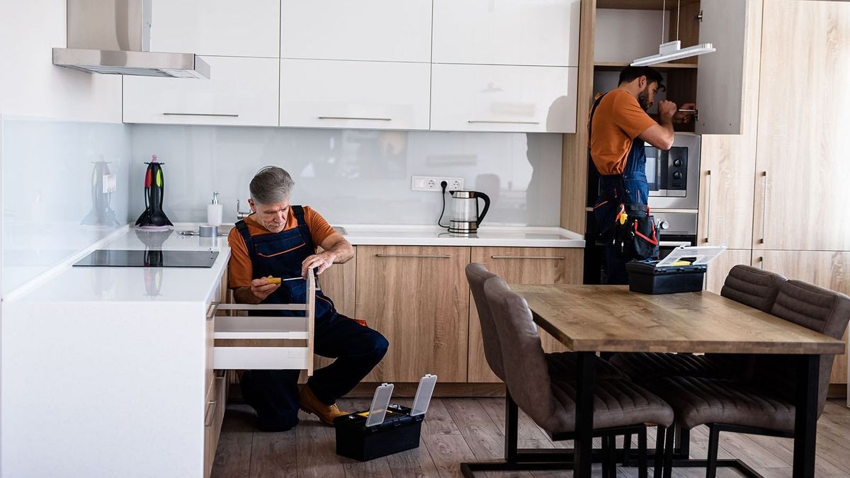 Full,Length,Shot,Of,Two,Handymen,,Workers,In,Uniform,Assembling
Full length shot of two handymen, workers in uniform assembling kitchen cupboard, cabinet using screwdriver indoors. Furniture repair and assembly concept. Horizontal shot