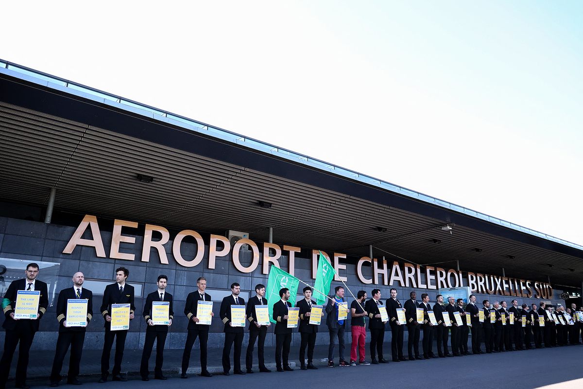 Ryanair pilots hold placards at the Charleroi Airport, in Charleroi on August 14, 2023 during a Ryanair pilots' strike over working conditions. (Photo by Kenzo TRIBOUILLARD / AFP)