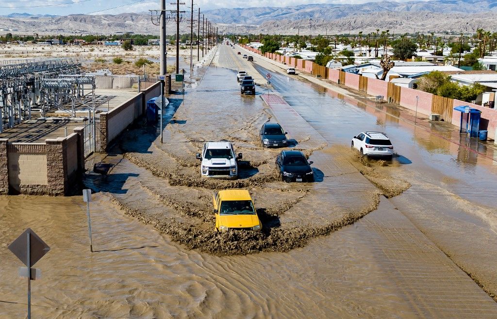 In this aerial picture taken on August 21, 2023 vehicles drive through floodwaters following heavy rains from Tropical Storm Hilary in Thousand Palms, California. Tropical Storm Hilary drenched Southern California with record rainfall, shutting down schools, roads and businesses before edging in on Nevada on August 21, 2023. California Governor Gavin Newsom had declared a state of emergency over much of the typically dry area, where flash flood warnings remained in effect until this morning. (Photo by JOSH EDELSON / AFP)