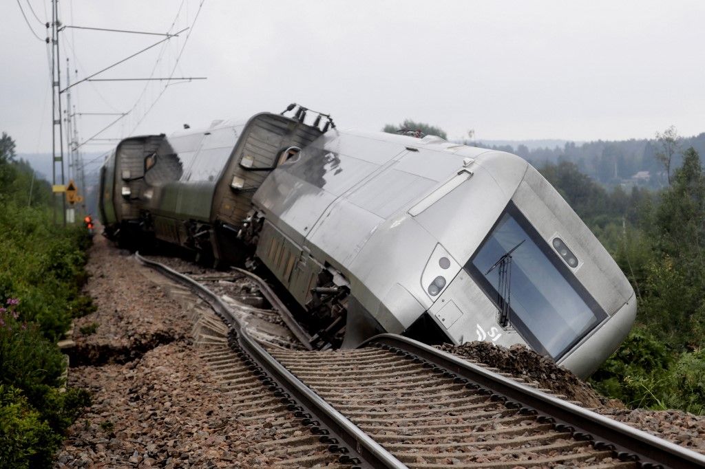 This photo taken on August 7, 2023 shows a derailed passenger train between Iggesund and Hudiksvall in Sweden. Three people have been taken to hospital, according to the police. The train carrying 120 passengers was on its way from Stockholm to Sundsvall when the front two of a total of four carriages derailed just south of Hudiksvall. The embankment was undermined as a result of heavy rain. (Photo by Mats ANDERSSON / various sources / AFP) / Sweden OUT