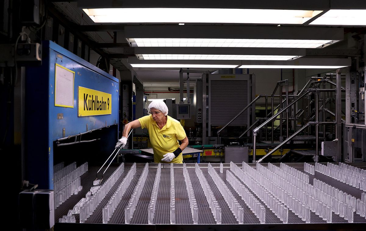 Quality controller Michaela Trebes inspects flacons on an assembly line at the German glass producer Heinz-Glas Group in Kleintettau, Germany on August 3, 2022. Over 400 years, Heinz-Glas, one of the world's biggest producers of glass perfume bottles, has seen off crises from the plague to world wars. But Germany's current energy emergency strikes at the heart of its very existence. (Photo by Ronny Hartmann / AFP)