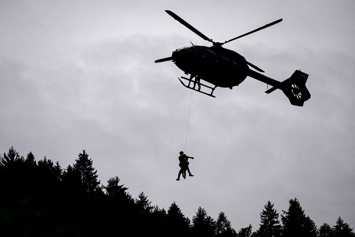 A inhabitant man is airlifted from an isolated flooded house in the flood-hit city of Prevalje, on August 9, 2023. Flash floods and landslides that began on August 3, 2023 had submerged large swathes of central and northern Slovenia, cutting off access to villages and disrupting traffic. (Photo by Jure Makovec / AFP)