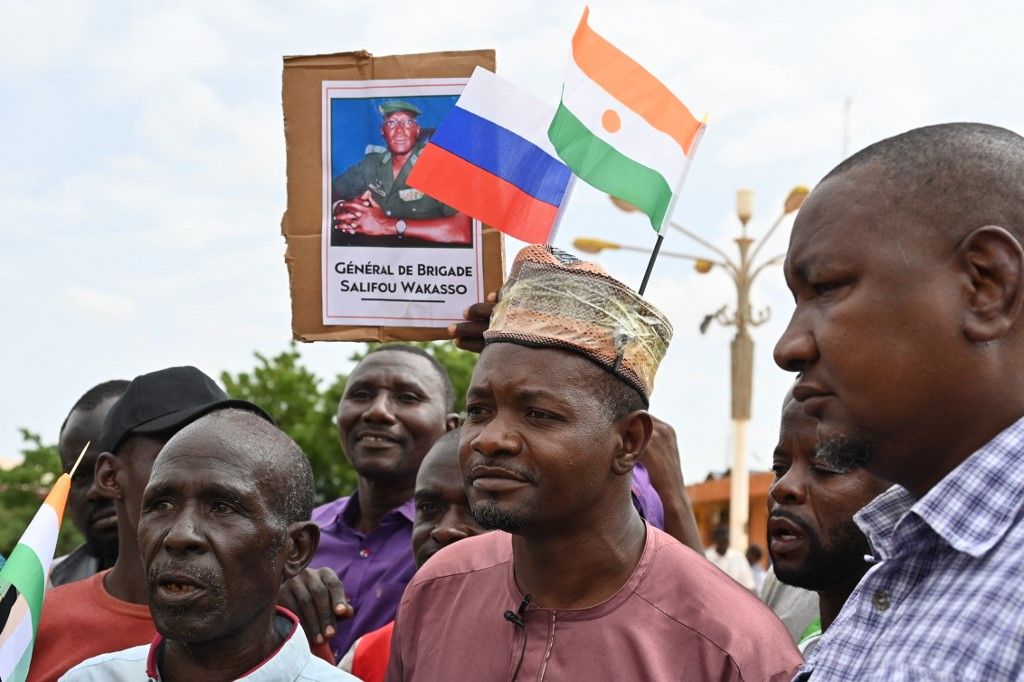 Supporters of Niger's National Council for the Safeguard of the Homeland (CNSP) wave Niger and Russian flags as they demonstrate in Niamey on August 6, 2023. Thousands of supporters of the military coup in Niger gathered at a Niamey stadium Sunday, when a deadline set by the West African regional bloc ECOWAS to return the deposed President Mohamed Bazoum to power is set to expire, according to AFP journalists. A delegation of members of the ruling National Council for the Safeguard of the Homeland (CNSP) arrived at the 30,000-seat stadium to cheers from supporters, many of whom were drapped in Russian flags and portraits of CNSP leaders. (Photo by AFP)