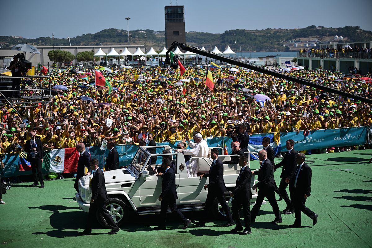 Pope Francis waves from the popemobile as he arrives for a meeting with volunteers of the World Young Day (WYD) in Alges, 10 km away from Lisbon, on August 6, 2023. Pope Francis celebrated an open-air Mass before a huge crowd today at a waterside park near Lisbon to wrap up the WYD, the largest Catholic gathering in the world, created in 1986 by John Paul II. Around 1.5 million people attended the service at the Parque Tejo park on the eastern outskirts of the Portuguese capital, the Vatican said. (Photo by Marco BERTORELLO / AFP)