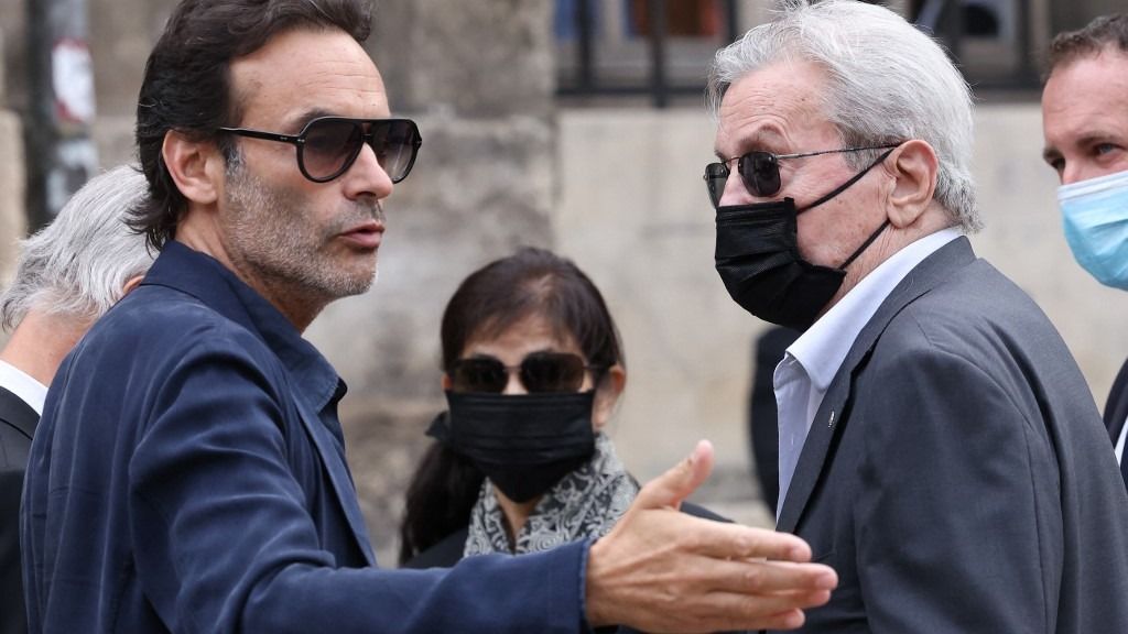 French actor Alain Delon (R), his partner and assistant Hiromi Rollin (C) and his son Anthony Delon arrive for the funeral ceremony for late French actor Jean-Paul Belmondo at the Saint-Germain-des-Pres church in Paris on September 10, 2021. Several hundred of attendees have gathered to pay their respects to one of the most popular French actors on September 9, 2021: his relatives, the French President and members of the government as well as personalities from the world of cinema, culture and sport. Belmondo died on September 6, 2021 aged 88. (Photo by Thomas COEX / AFP)