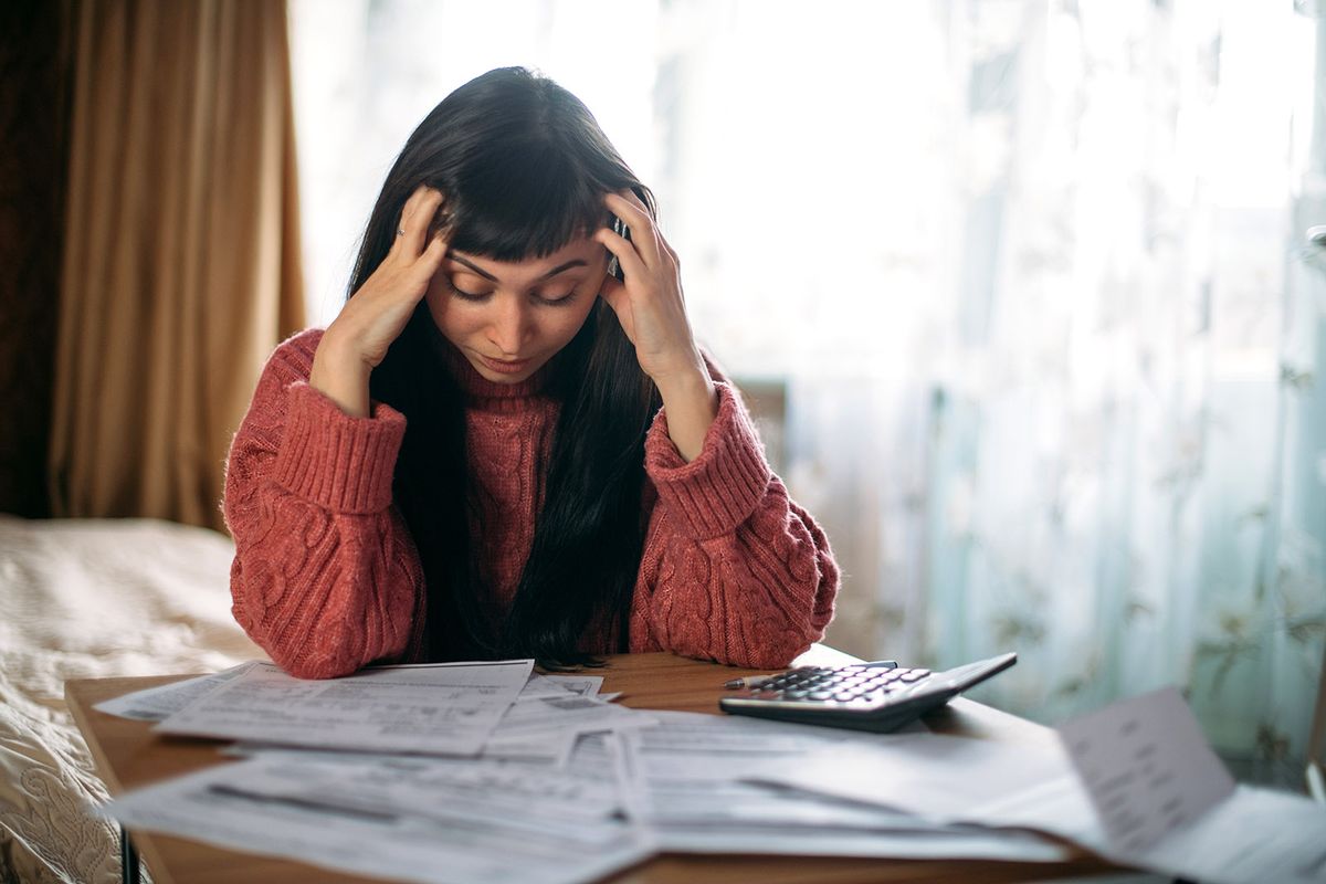 Sad,Woman,Holding,Her,Head,Over,Utility,Bills.,The,Concept Sad woman holding her head over utility bills. The concept of rising prices for heating, gas, electricity. A young worried dissatisfied girl looks at papers does not expect a high cost of services
gázszámla, gáz, számla, rezsi