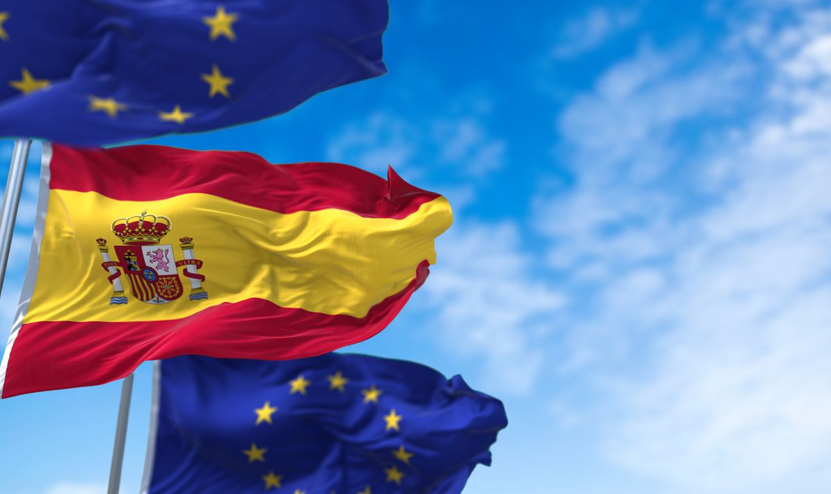 The,National,Flag,Of,Spain,Waving,Between,Two,European,Union