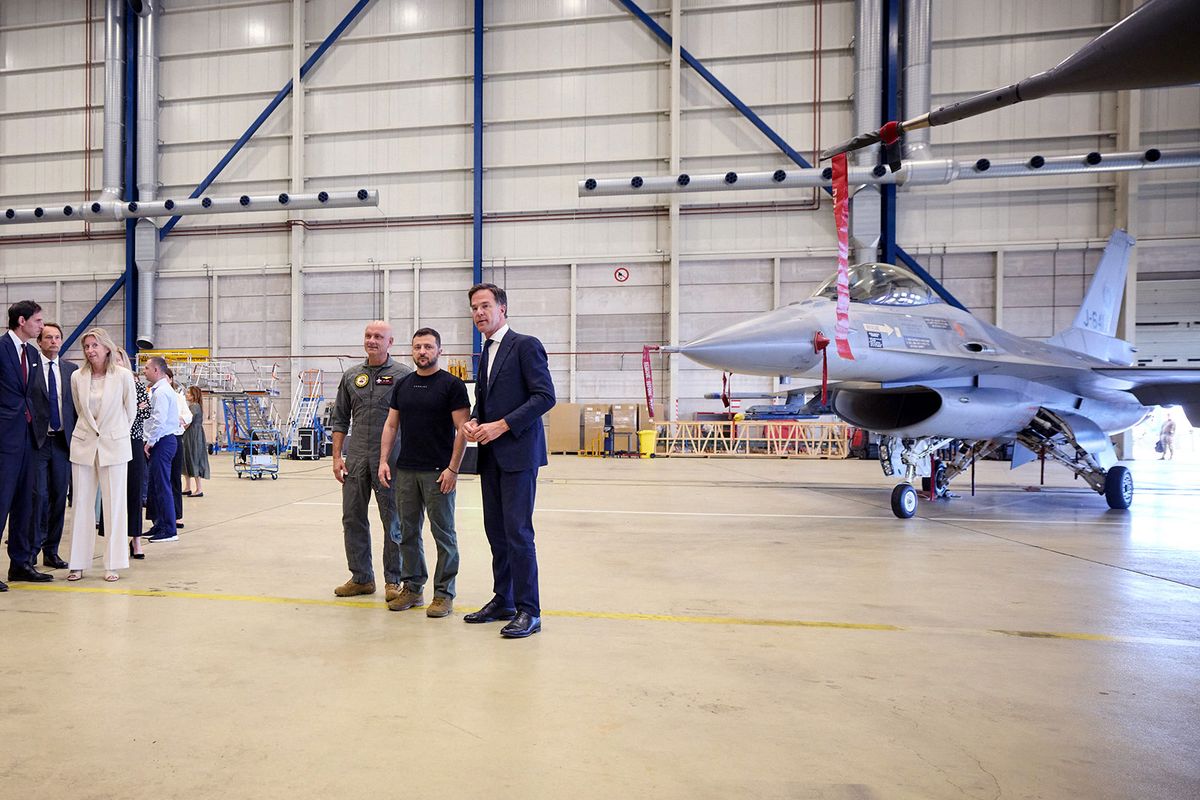 This photograph taken and released by the Ukrainian Presidential Press Service on August 20, 2023, shows Ukraine's President Volodymyr Zelensky (2nd-R) and Dutch Prime Minister Mark Rutte (R) standing next to a F-16 fighter jet in the hangar at the Eindhoven Military Air Base in Eindhoven. (Photo by Handout / UKRAINIAN PRESIDENTIAL PRESS SERVICE / AFP) / RESTRICTED TO EDITORIAL USE - MANDATORY CREDIT "AFP PHOTO / UKRANIAN PRESIDENTIAL PRESS SERVICE" - NO MARKETING NO ADVERTISING CAMPAIGNS - DISTRIBUTED AS A SERVICE TO CLIENTS