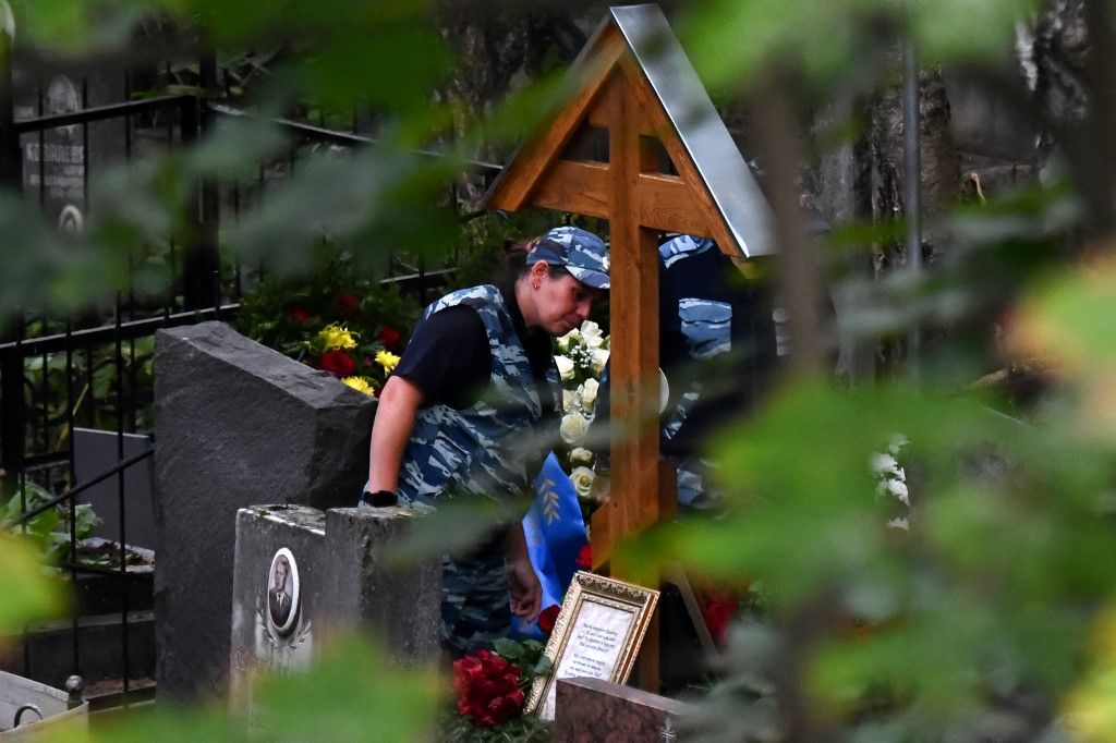 Police officers stand by the grave of Wagner private mercenary group chief Yevgeny Prigozhin, who was killed in a private jet crash in the Tver region last week, after his funeral at the Porokhovskoye cemetery in Saint Petersburg on August 29, 2023. (Photo by Olga MALTSEVA / AFP)