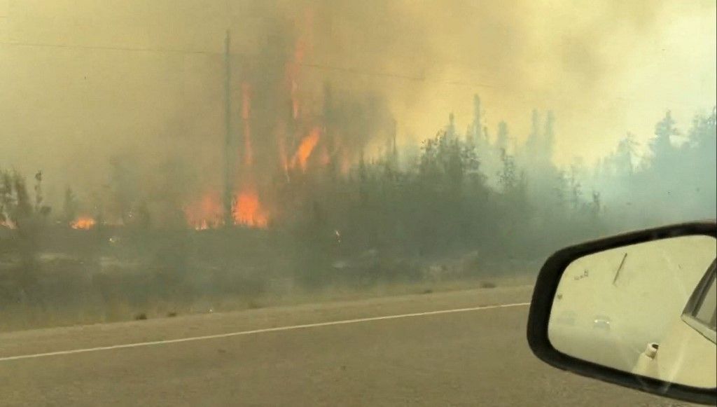 This screengrab from a video provided by Jordan Straker shows vehicles driving on the freeway as people evacuate from Yellowkife, Northwest Territories, Canada, on August 16, 2023. Thousands ordered to flee wildfires advancing on one of the largest cities in Canada's far north crammed into a local airport on August 17, 2023, to board emergency evacuation flights, as convoys snaked south to safety on the only open highway. The order late on August 16, 2023, to evacuate Yellowknife in the Northwest Territories marked the latest chapter of a terrible summer for wildfires in Canada, with tens of thousands of people forced to leave their homes and vast swathes of land scorched. (Photo by Jordan Straker / UGC / AFP) / RESTRICTED TO EDITORIAL USE – MANDATORY CREDIT «  AFP PHOTO / Jordan Straker  » - NO MARKETING NO ADVERTISING CAMPAIGNS – DISTRIBUTED AS A SERVICE TO CLIENTS [ NO ARCHIVE ]