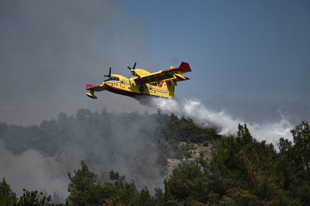 (FILES) A picture taken on August 24, 2023 shows a Canadair amphibious aircraft, droping water over wildfires spreading in Dadia forest near Alexandroupoli, north Greece, on August 24, 2023. (Photo by Sakis MITROLIDIS / AFP)