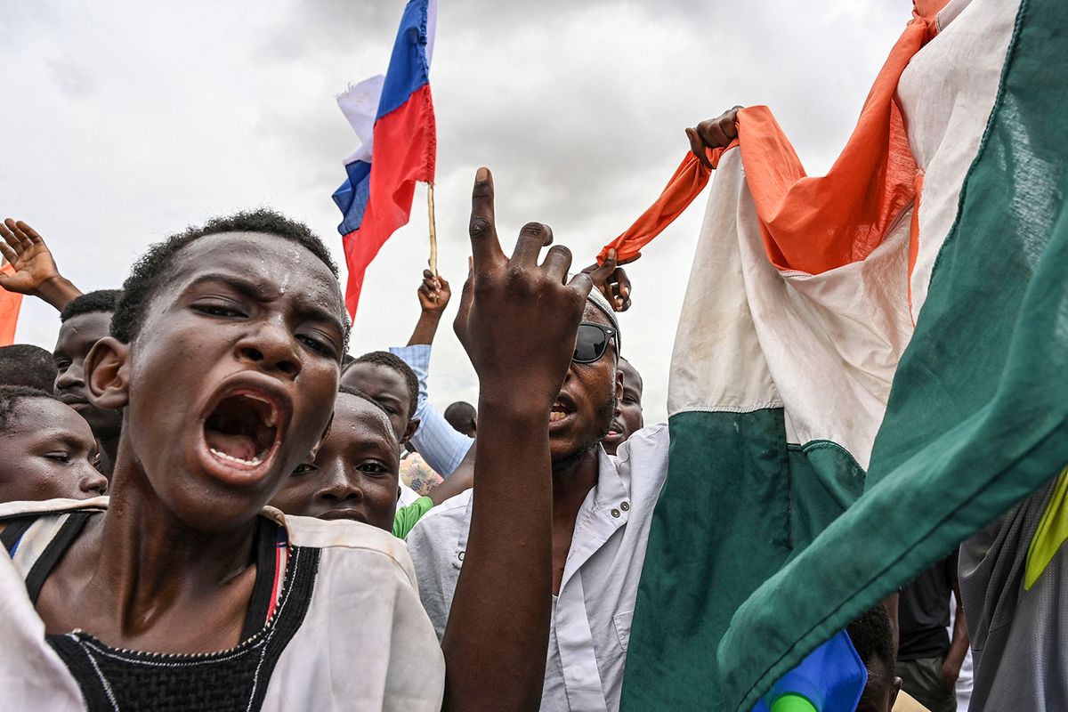 Supporters of Niger's National Council for the Safeguard of the Homeland (CNSP) wave the Russian and Nigerien Flags as they gather for a demonstration in Niamey on August 11, 2023 near a French airbase in Niger. Thousands of supporters of Niger's coup leaders gathered on August 11, 2023 near a French military base on the outskirts of the capital Niamey. Protesters shouted "down with France, down with ECOWAS", a reference to the West African bloc which on Thursday approved deployment of a "standby force to restore constitutional order" in Niger. (Photo by AFP)