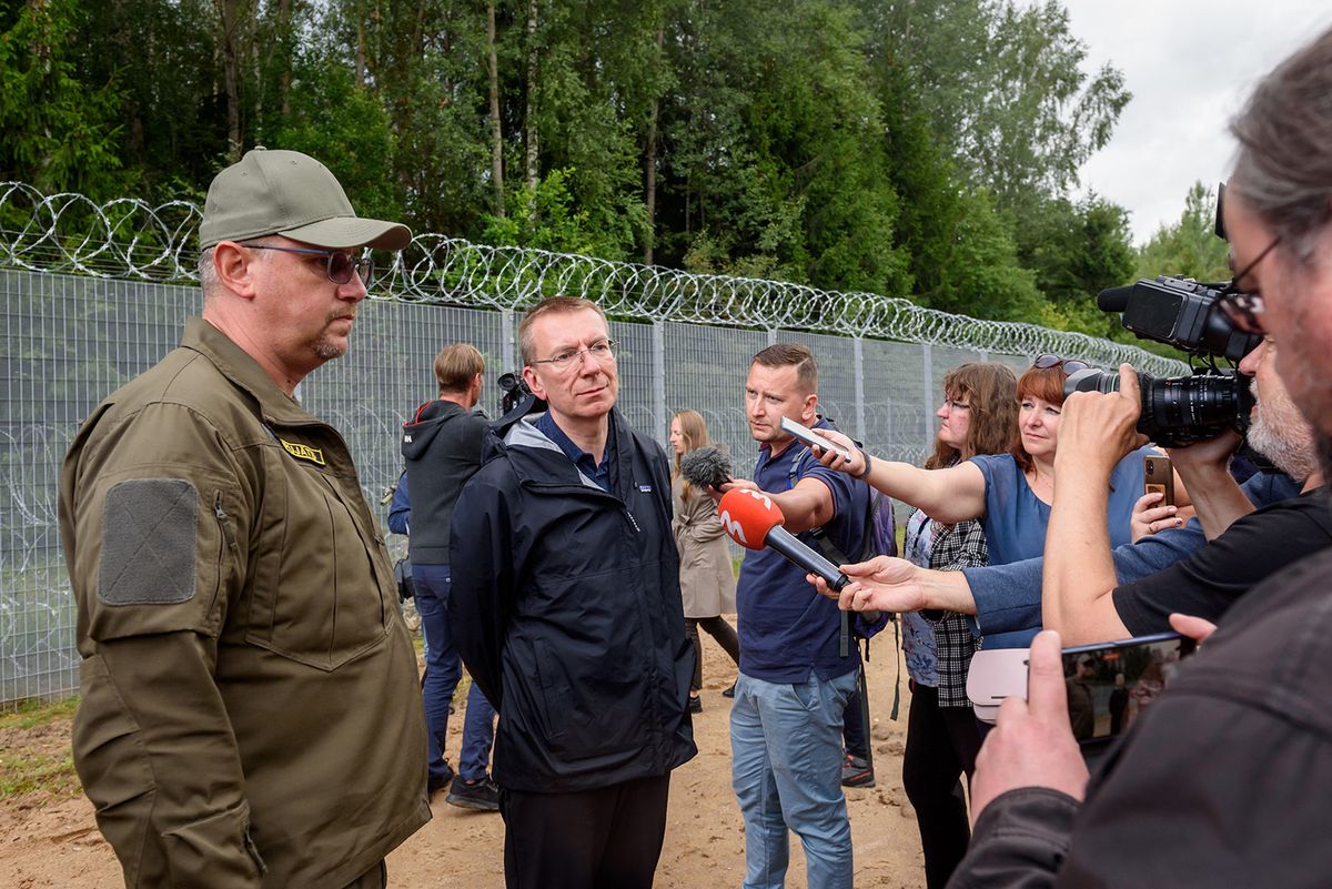 Edgars Rinkevics (C), President of Latvia speaks to journalists as he visits the Latvia/Belarus border near Krivanda, Eastern Latvia on August 8, 2023. (Photo by Gints Ivuskans / AFP)