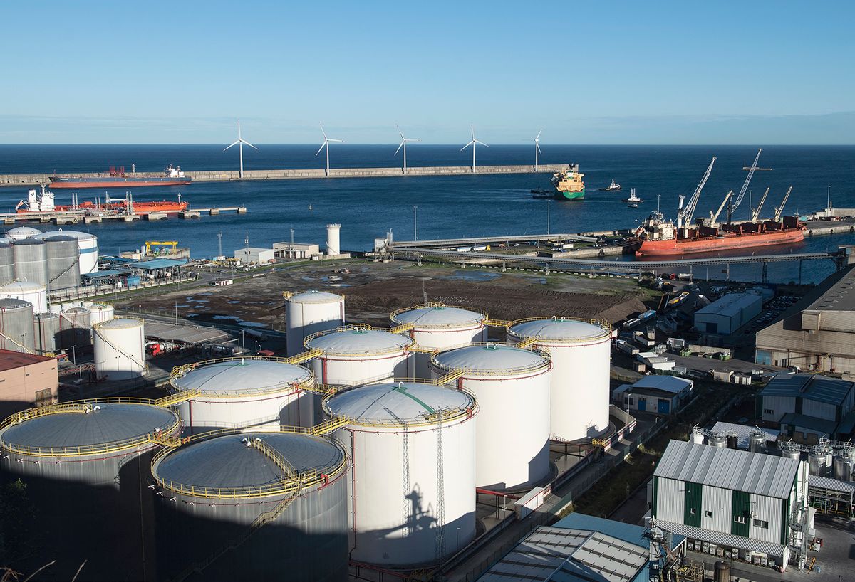 Tugboats help the vessel LNG Ogun (C), a gas tanker sailing under the flag of Bermuda, as she leaves the Port of Bilbao bound for the port of Bonny, in Nigeria, after her stopover at the Bizkaia Bay Gas (BBG) regasification plant in Zierbena, 20 km away from Bilbao, on December 21, 2022. Bahia de Bizkaia Gas liquefied natural gas regasification plant gets LNG from tankers from all over the world and transform it into natural gas for domestic, commercial and industrial consumption as well as for the electricity generation. (Photo by ANDER GILLENEA / AFP)