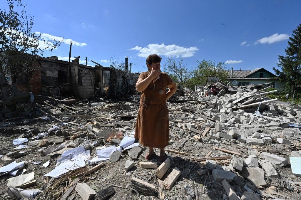Tatyana Skrypnikova, 60, who sustained light shrapnel wounds, stands among debris of the house of her neighbours destroyed following a shelling in the village ofnZaoskillya, near Kupiansk, Kharkiv Oblast, on August 17, 2023, amid the Russian invasion of Ukraine. The head of the region Oleg Synegubov said that Russian forces had shelled Zaoskillya, a suburb just east of Kupiansk, killing a woman born in 1962. "Another woman, born in 1963, suffered shrapnel wounds. Medics provided assistance to the injured on the spot," he wrote on social media. (Photo by SERGEY BOBOK / AFP)