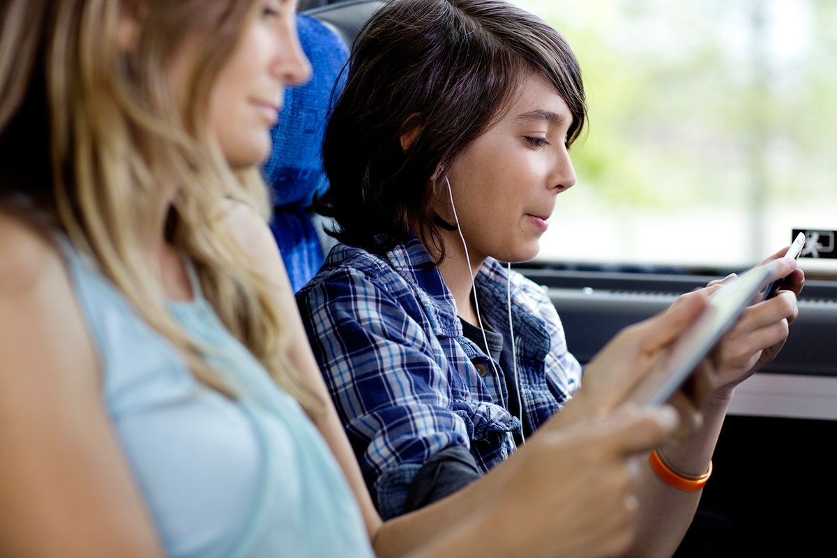 Boy using mobile while sitting in the bus