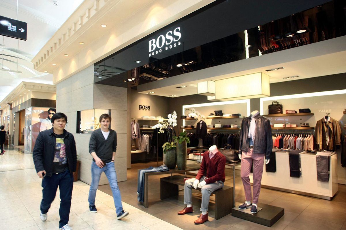 Hugo Boss dresses up its China efforts
--FILE--Shoppers walk past the Hugo Boss boutique at the No.1 Yaohan Department Store in Pudong, Shanghai, China, 5 April 2012.German high-end fashion label Hugo Boss is cooking up plans to make China one of its biggest markets, just as growth in the countrys luxury space appears to be cooling off. The maker of upscale sportswear and suits plans to open about 60 new stores in Chinas mainland over the next three years, adding to its current 86 stores, Hugo Boss Chief Executive Claus-Dietrich Lahrs said. The expansion is part of an effort to boost revenue from Asia to 20% of the labels global sales by 2015 from 15% last year, he said. (Photo by Weng lei / Imaginechina / Imaginechina via AFP)