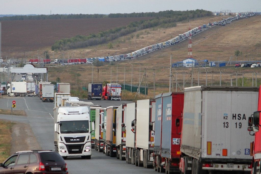 Cars (background) are seen queueing on the Russian side of the border with Kazakhstan near the Kazakh Syrym crossing point on September 27, 2022. Russian President Vladimir Putin announced on September 21 a mobilisation of hundreds of thousands of Russian men to bolster Moscow's army in Ukraine, sparking demonstrations and an exodus of men abroad. (Photo by STRINGER / AFP)