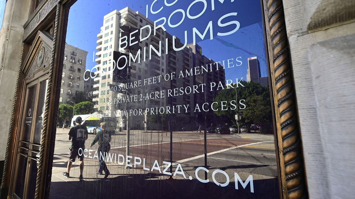 Pedestrians walk past the offices of Oceanwide Holdings, promoting iconic bedroom condos for the unfinished Oceanwide Plaza in Los Angeles, California on January 25, 2019, one of the biggest real estate development projects in downtown LA where constuction has stalled as the Beijing-based Oceanwide Holdings conglomerate said the hold-up was due to a recapitalization of the project, with work due to resume by the middle of February. China has been a major investor in real eastate projects in downtown Los Angeles for a number of years and last week the FBI announced a corruption probe examining whether Chinese real estate developers bribed Los Angeles officials to win bids. (Photo by Frederic J. BROWN / AFP)