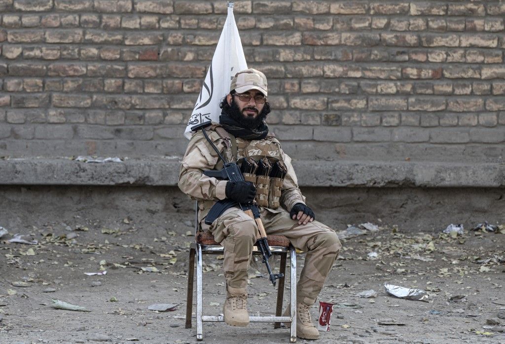 A Taliban security personnel sits on a chair along the roadside in Kabul on September 7, 2023. (Photo by Wakil KOHSAR / AFP)