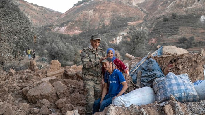 A Moroccan soldier comforts a man sitting on rubble in the mountainous area of Tizi N'Test, in the Taroudant province, one of the most devastated in quake-hit Morocco, on September 11, 2023. Medics treated a constant flow of casualties after Morocco's strongest-ever earthquake killed more than 2,800 people, but  on september 12 hopes of finding more survivors under the rubble were fading. (Photo by BULENT KILIC / AFP)