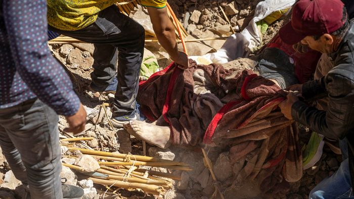 EDITORS NOTE: Graphic content / Volunteers recover a body from the rubble of collapsed houses in Tafeghaghte, 60 kilometres (37 miles) southwest of Marrakesh, on September 10, 2023, two days after a devastating 6.8-magnitude earthquake struck the country. Moroccans on September 10 mourned the victims of a devastating earthquake that killed more than 2,000 people as rescue teams raced to find survivors trapped under the rubble of flattened villages. (Photo by FADEL SENNA / AFP)