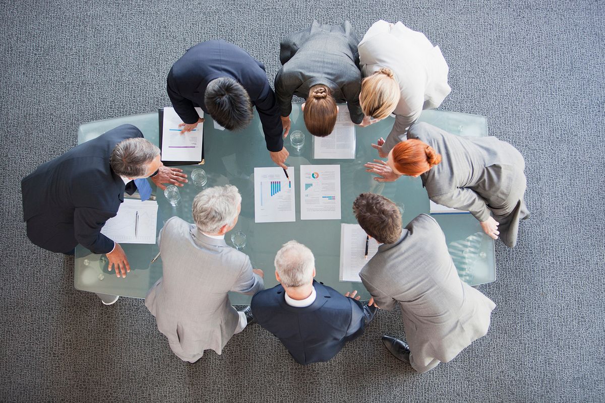 Business people huddled around paperwork on table
vállalati kommunikáció, PR, 