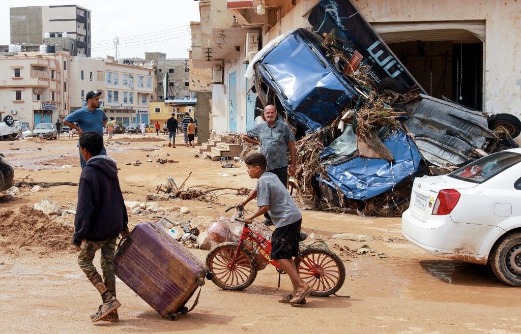 A boy pulls a suitcase past debris in a flash-flood damaged area in Derna, eastern Libya, on September 11, 2023. Flash floods in eastern Libya killed more than 2,300 people in the Mediterranean coastal city of Derna alone, the emergency services of the Tripoli-based government said on September 12. (Photo by AFP)