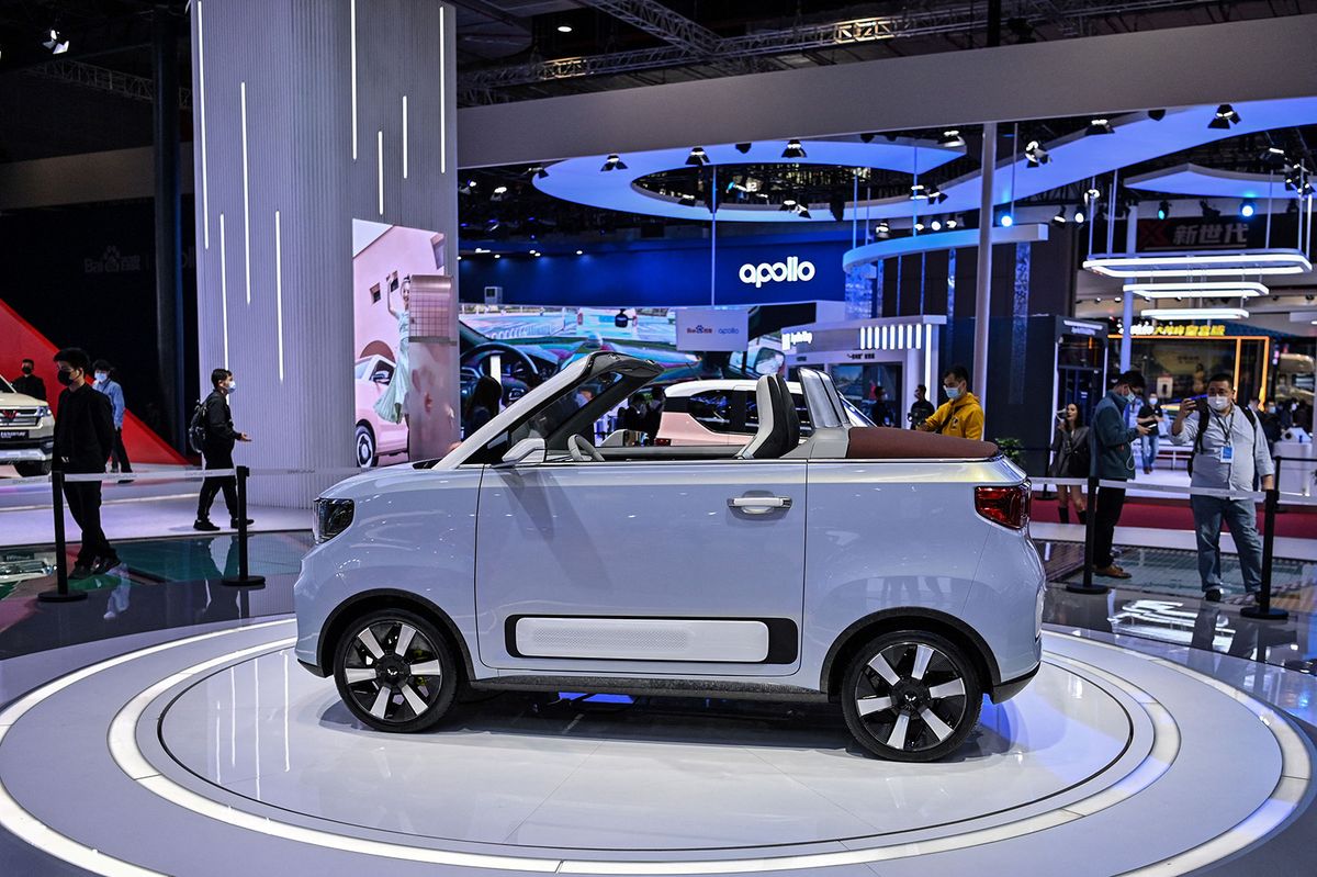 People look at a Wuling Hong Guang Mini EV during the 19th Shanghai International Automobile Industry Exhibition in Shanghai on April 20, 2021. (Photo by Hector RETAMAL / AFP)