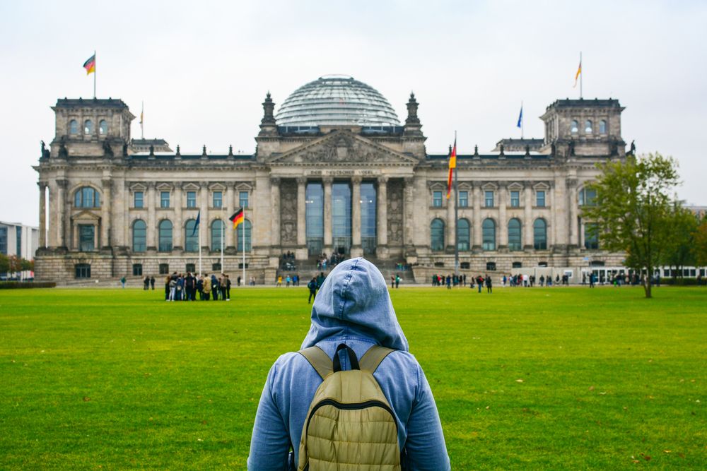 Young,Woman,With,Backpack,Looking,At,Bundestag,Building,In,Berlin.