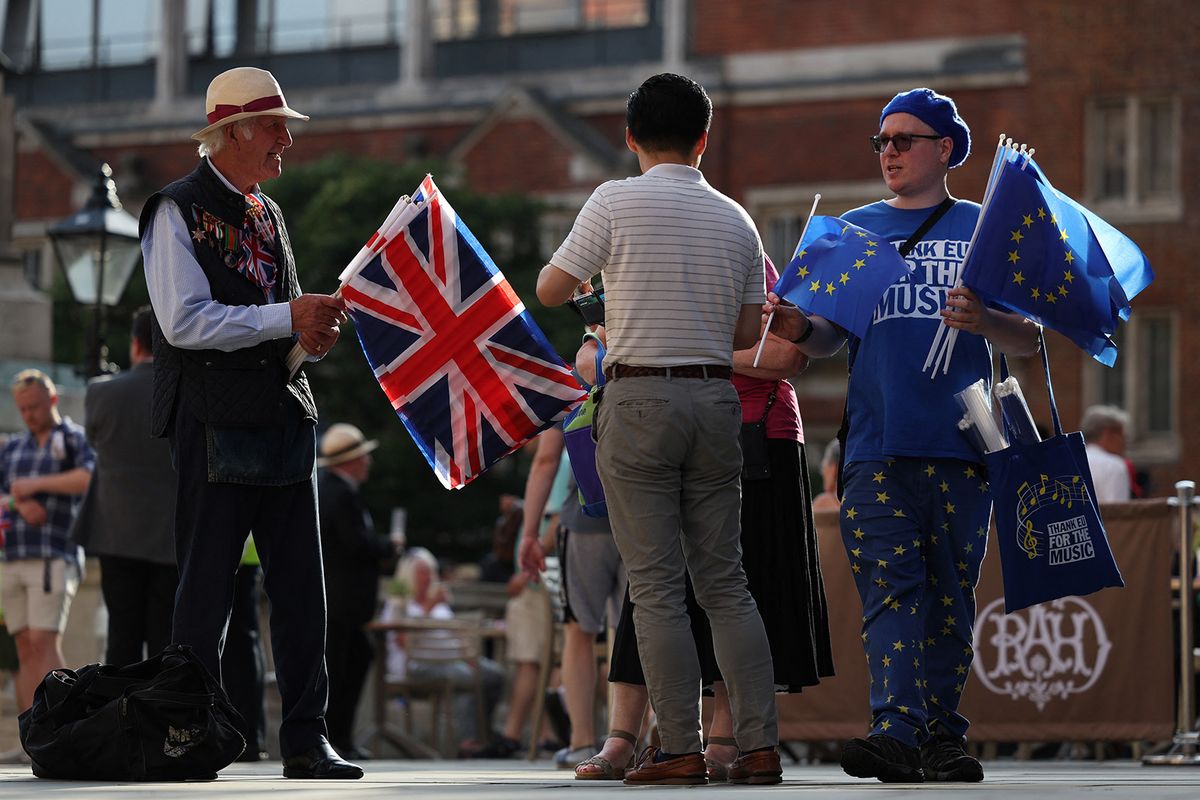 A pro-EU activist (R) hands out EU flags beside a Union flag seller (L) as concert-goers arrive at the Royal Albert Hall in London on September 9, 2023, for the Last Night of the Proms concert. Activists distribute European flags in an anti-Brexit demonstration to concert goers outside the venue of the annual Last Night of the Proms, and the traditional Union flag flying inside in the Royal Albert Hall. (Photo by Adrian DENNIS / AFP)