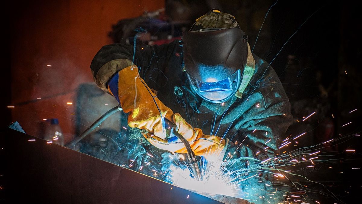 Worker,Welding,Metal,With,Sparks,At,Factory