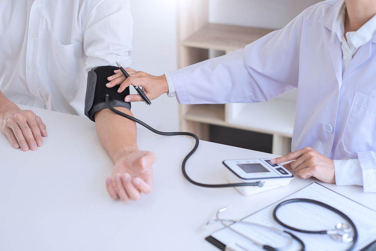 Doctor,Measuring,And,Checking,Blood,Pressure,Of,Patient,In,Hospital,Doctor measuring and checking blood pressure of patient in hospital, Health care and medicine concept